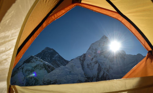 Snowcapped mountain seen from tent on sunny day