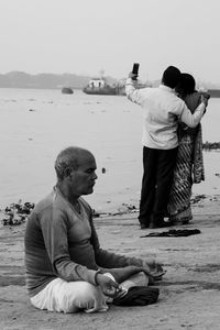 Rear view of man photographing on beach