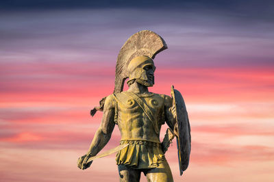 Statue of king leonidas of ancient sparta with sunset clouds in the background