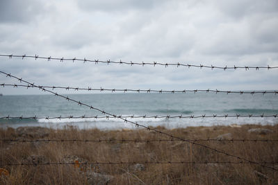 Travel restrictions. the sea beyond the fence with barbed wire