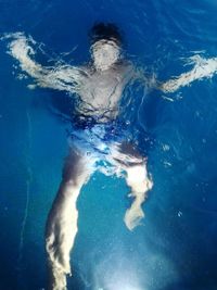 High angle view of shirtless teenager boy swimming in sea