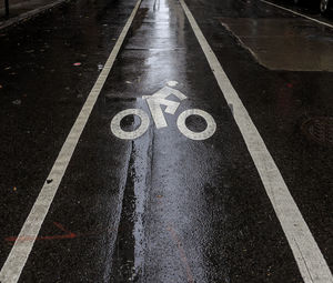 High angle view of road sign on wet street