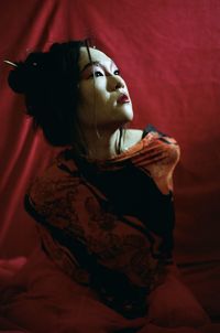 Portrait of young woman relaxing on bed at home