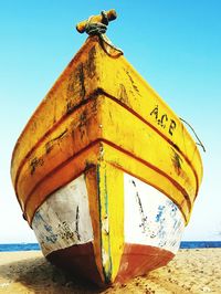 Low angle view of information sign on beach against clear sky