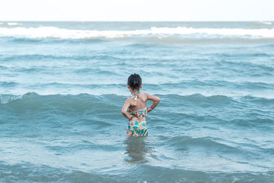 Full length of shirtless boy in sea