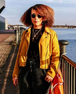Portrait of young woman wearing sunglasses while standing in city