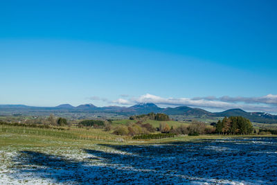 Scenic view of landscape against blue sky