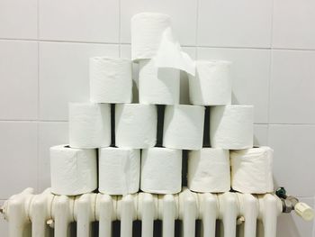 Stack of tissue papers on radiator against tiled wall