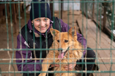 Volunteer in the nursery for dogs. woman volunteer in a cage with a stray dog at an animal shelter