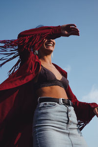 Low angle view of woman standing against sky