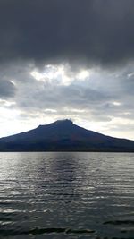 Scenic view of lake by mountains against sky