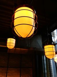 Low angle view of illuminated lamp hanging on ceiling