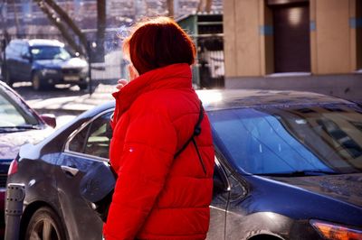 Rear view of woman with umbrella in city during winter