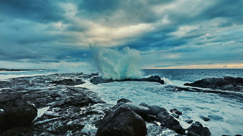 Scenic view of rocks on beach against sky