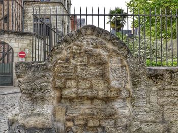 Old statue amidst buildings in city