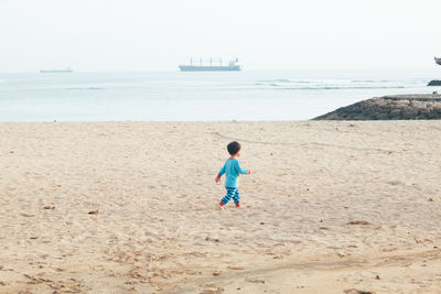 Full length of boy running at beach