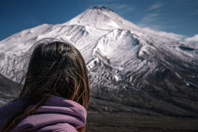 Rear view of woman with snowcapped mountains against sky