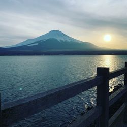 Scenic view of lake by snowcapped mountains against sky