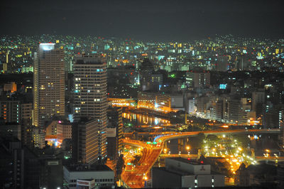 Illuminated cityscape against sky at night