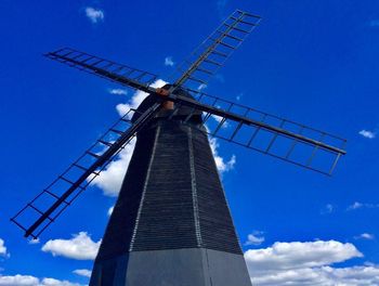 Low angle view of traditional windmill against blue sky