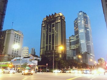 Low angle view of illuminated buildings against blue sky