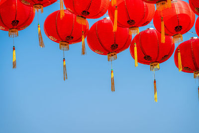 Low angle view of lanterns hanging against sky