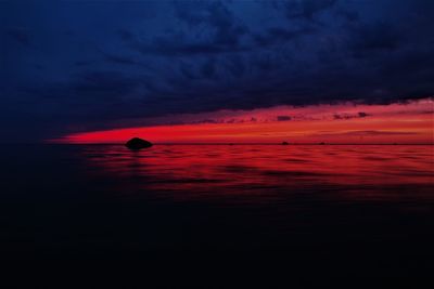 Scenic view of sea against dramatic sky during sunset