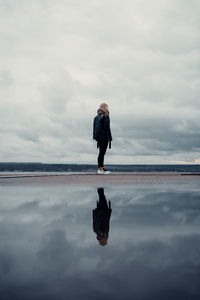 Full length of woman standing on sea against sky