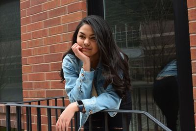 Young woman leaning against railing