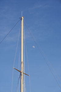 Low angle view of sailboat against clear blue sky
