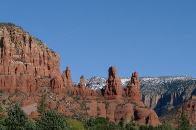 Rock formations on mountain against blue sky