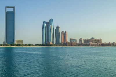 City at waterfront against clear sky