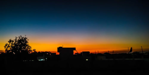 Silhouette buildings against sky during sunset