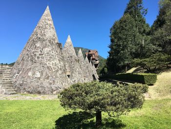 Trees growing outside temple against clear sky