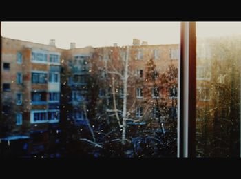 Digital composite image of buildings seen through glass window