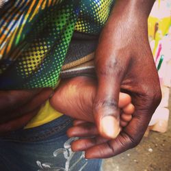 Cropped image of hand touching baby foot