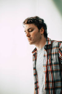 Young man standing against wall