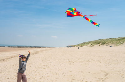 Cute boy on beach against sky