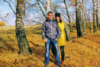 Full length portrait of a smiling young woman in forest