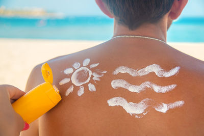 Rear view of woman hand on beach