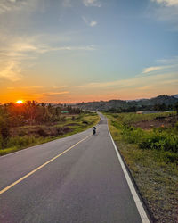 Road amidst landscape against sky during sunset