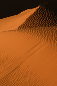 Sand dunes in desert against sky