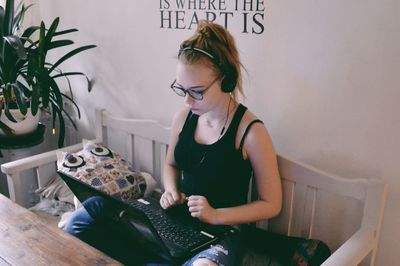 Young woman looking away while sitting at home