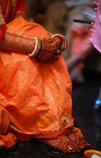 Low section of cropped hand of woman in her wedding dress 