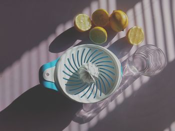 Directly above shot of lemons with squeezer on table