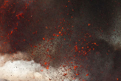 Close-up of red fire on water against black background