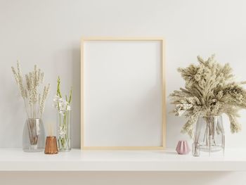 Flower vase on table against wall at home