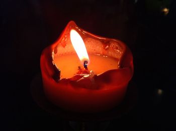 Close-up of lit candle in dark room