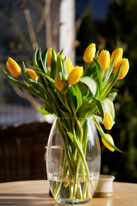Close-up of yellow flowers in glass vase