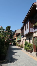 Street amidst buildings against blue sky